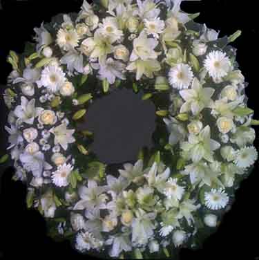 corona funebre de 1 metro de diametro con rosas blancas lilis blancas gerberas blancas follaje verde
        