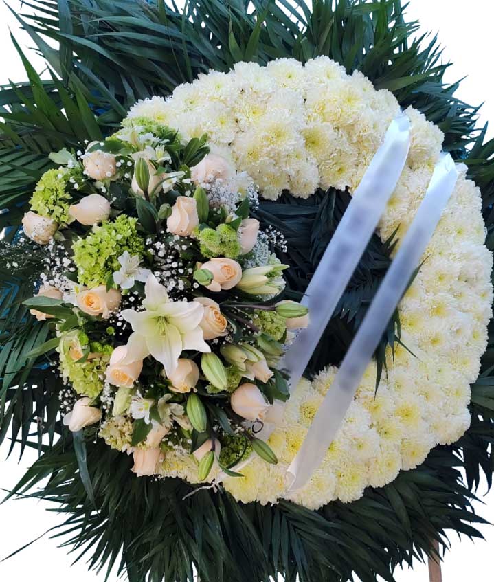 corona para funeral con pompones,rosas hortencias babi breat lilis follaje y palma